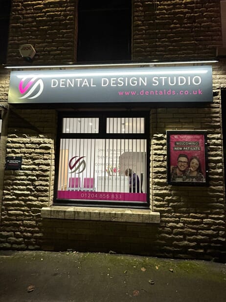 An image of exterior signage and window graphics for a dentist.